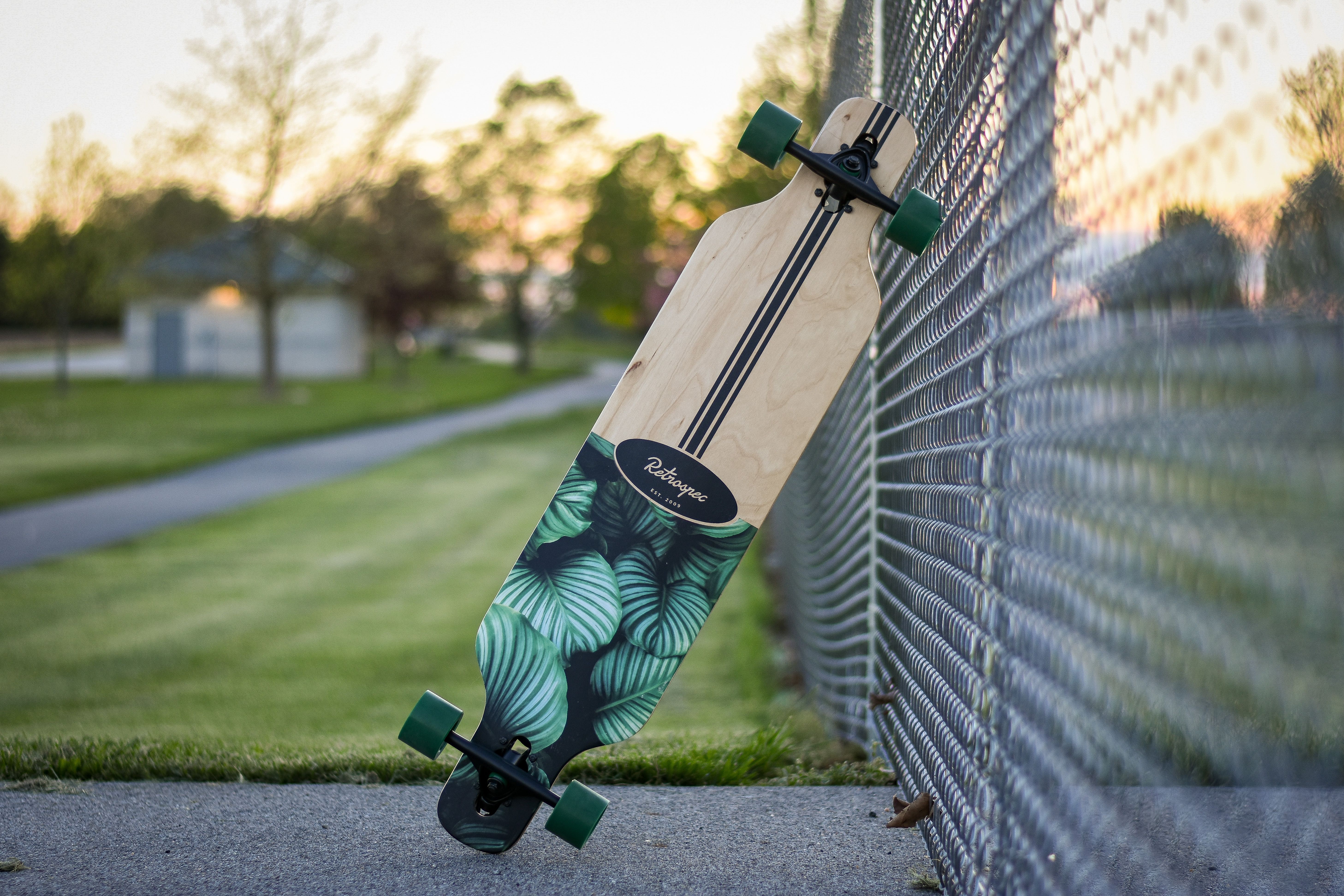 Một deck ván trượt cũ đặt trên bàn gỗ, cạnh đó là thước đo và kính lúp kiểm tra bề mặt