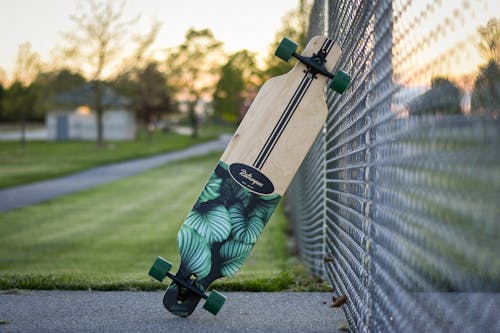 Photo of a Longboard on Chain Link Fence
