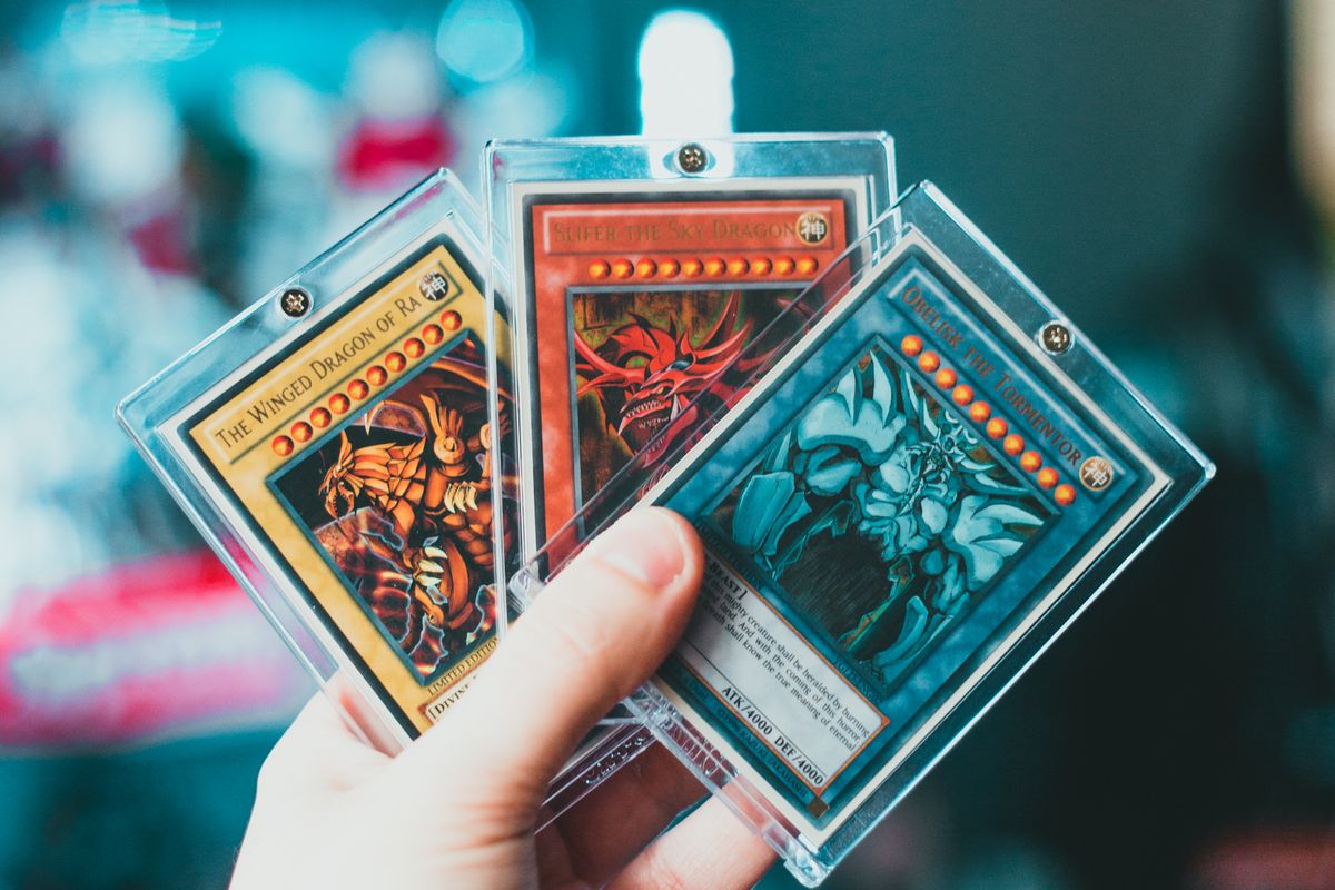 Hand holding collectible trading cards in protective cases