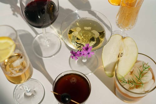 Glasses of cocktails decorated with pear and blooming flowers