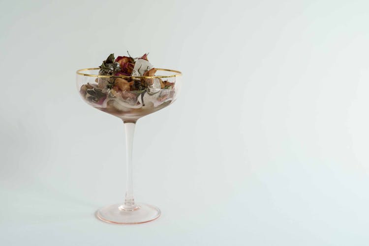 Glass Of Melting Ice With Dried Flowers