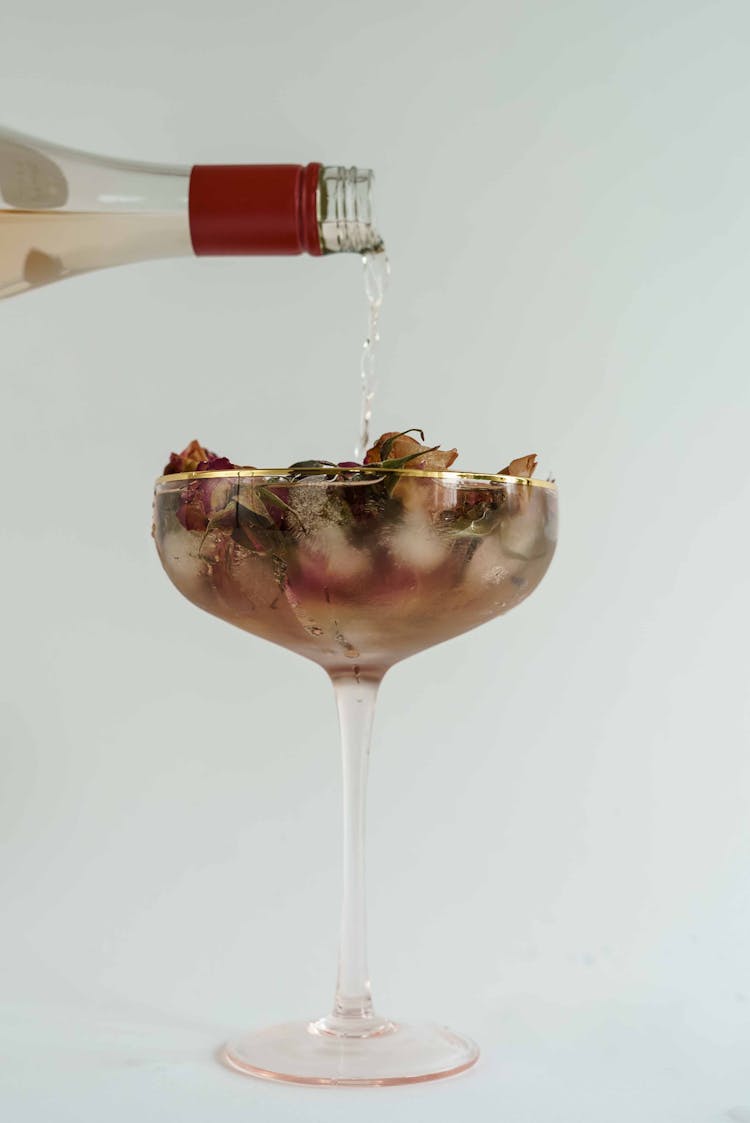 Alcoholic Drink Pouring Into Glass With Ice Cubes