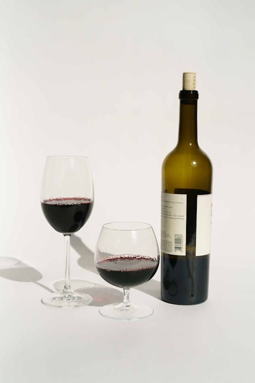 Free Bottle of red wine near glasses in studio Stock Photo