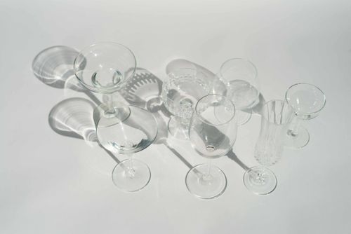 Free High angle of transparent different glasses for various cocktails and beverages in white studio Stock Photo