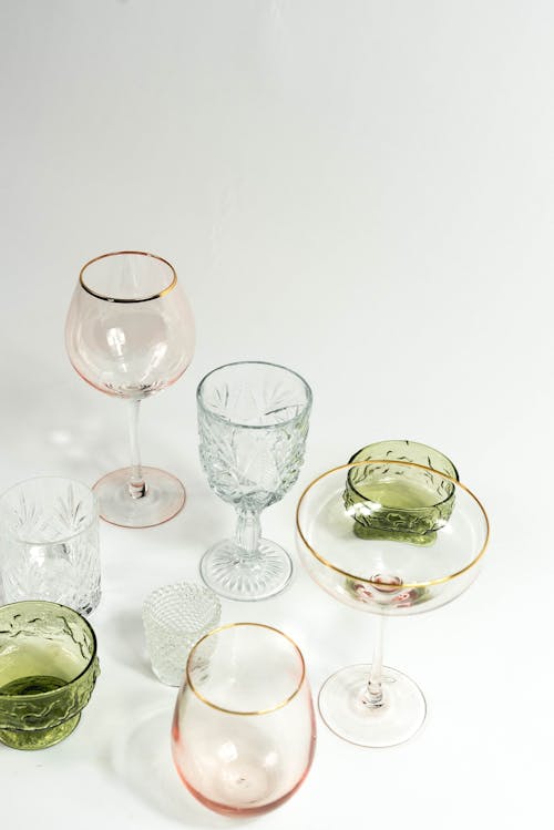 Free From above collection of empty colorful glassware for different drinks with different sizes placed on white background in light studio Stock Photo
