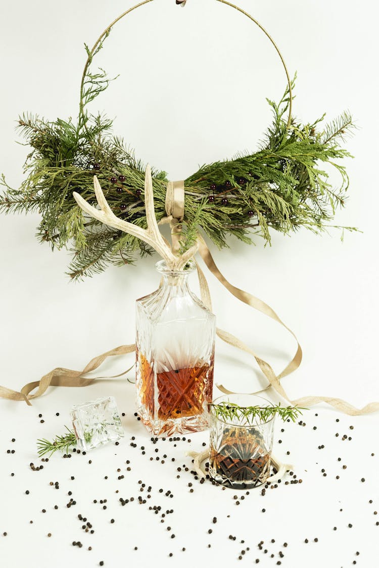 Glassware With Whiskey Near Rosemary Wreath