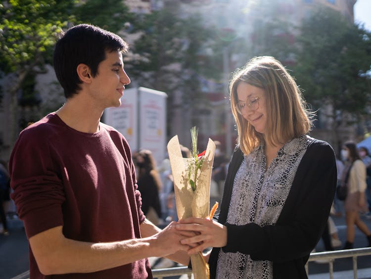 A Man Giving A Red Rose To His Woman