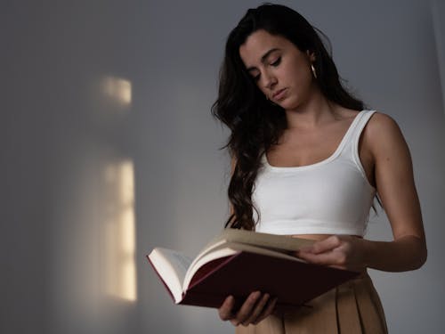 Woman in White Crop Top Reading a Book