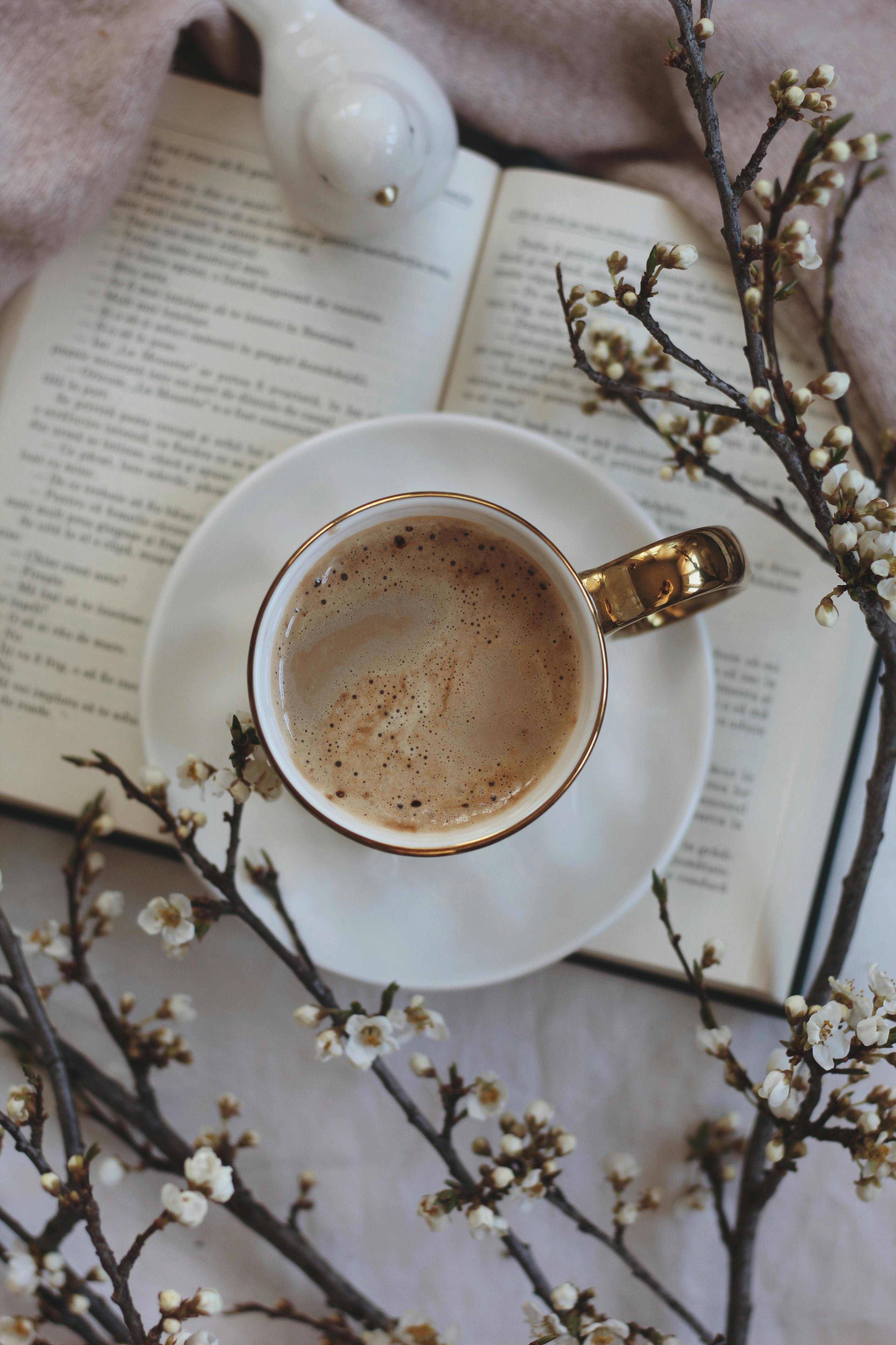 cup of coffee on book near decorations