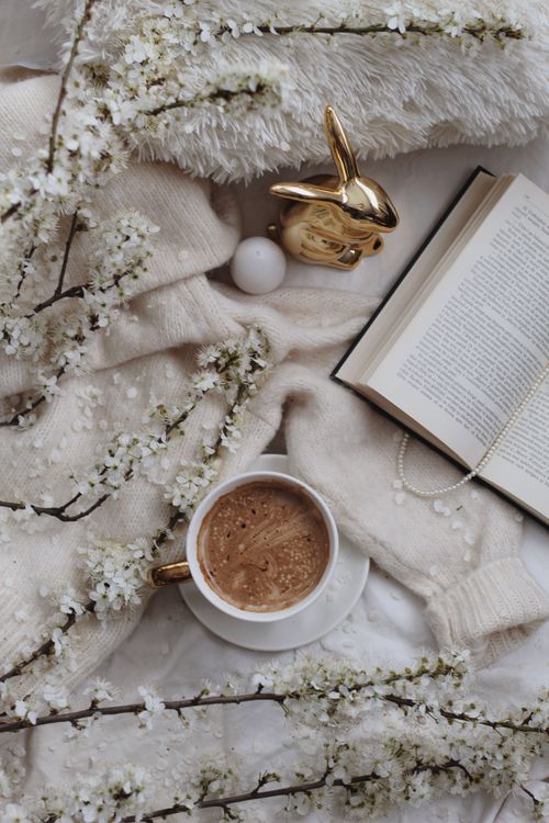 Free From above of coffee on soft plaid with blooming sprigs and egg near decorative bunny in light room during Easter holiday Stock Photo