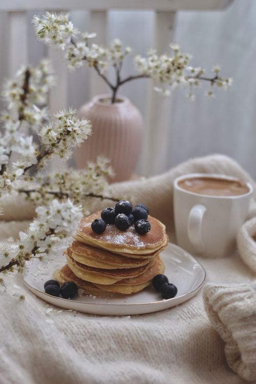 Free A comforting stack of pancakes with blueberries and coffee, perfect for a cozy breakfast. Stock Photo