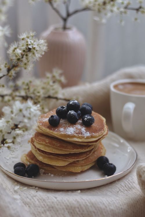 Free A cozy breakfast scene featuring a stack of blueberry pancakes with a cup of coffee. Stock Photo