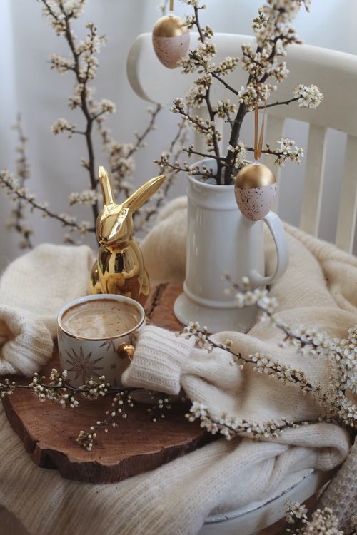 Free Cup of hot coffee placed on wooden tray with Easter decorations on white chair in light room during holiday celebration Stock Photo