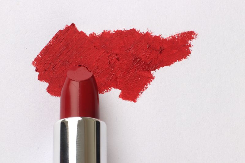 Vibrant red lipstick smear on paper for beauty and makeup themes.