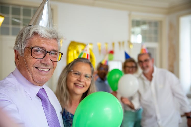 Elderly Man Wearing Party Hat Smiling