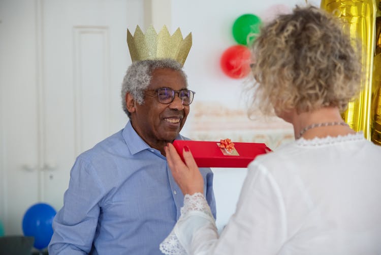 Woman Giving Gift To An Elderly Man