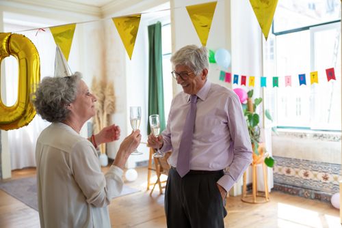 Free Senior couple enjoying a festive celebration with champagne indoors. Stock Photo