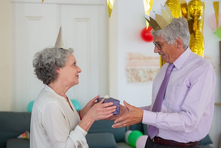 A Woman Giving A Gift To A Man