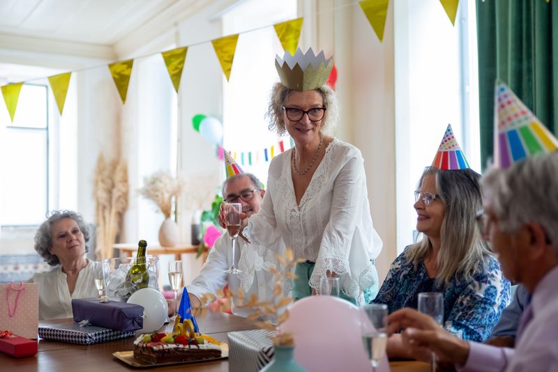 Elderly guests enjoying a birthday party together at a table