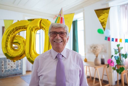 Happy senior man celebrates 60th birthday with balloons and decorations indoors.