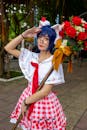 A Cosplayer Holding Red Roses while Posing at the Camera