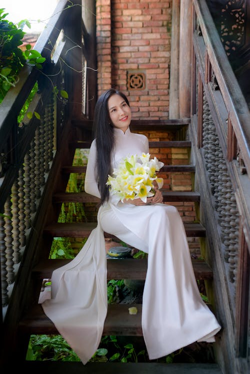Free Woman in White Wedding Gown Holding Bouquet of Flowers Stock Photo