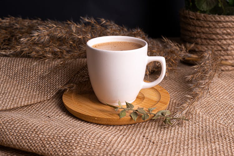 White Ceramic Mug On Brown Wooden Coaster