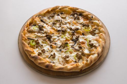 Free A mouthwatering close-up of a pizza with toppings, baked on a wooden board. Stock Photo