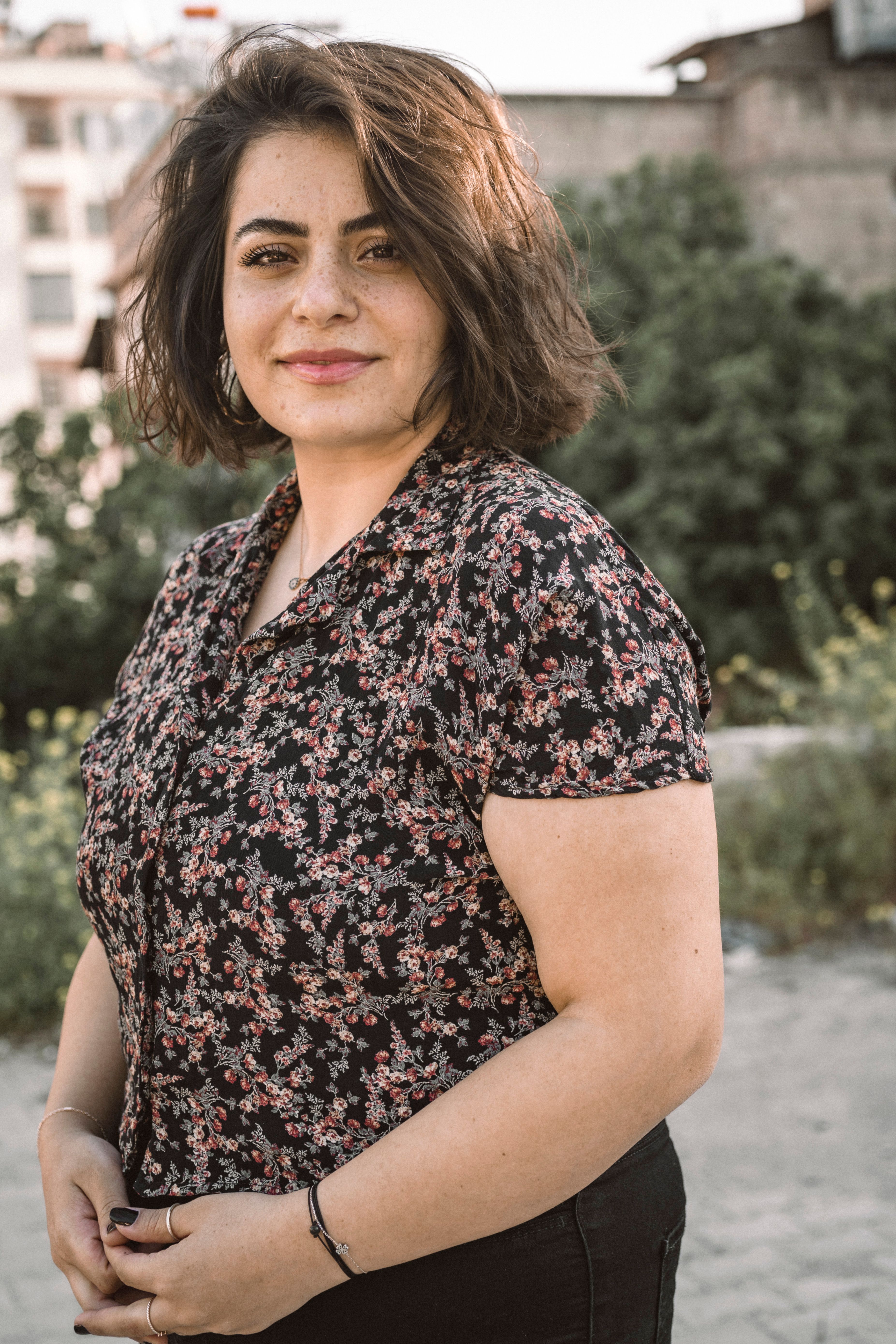 Charming portrait of a woman in a floral top, outdoors in Gaziantep, Turkey.