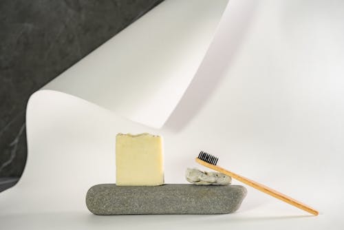 Yellow Cheese and Charcoal Toothbrush on Gray Rock