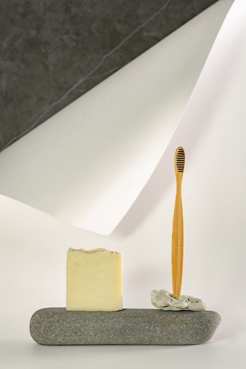 Free Photo of a Soap and a Wooden Toothbrush on a Stone Stock Photo