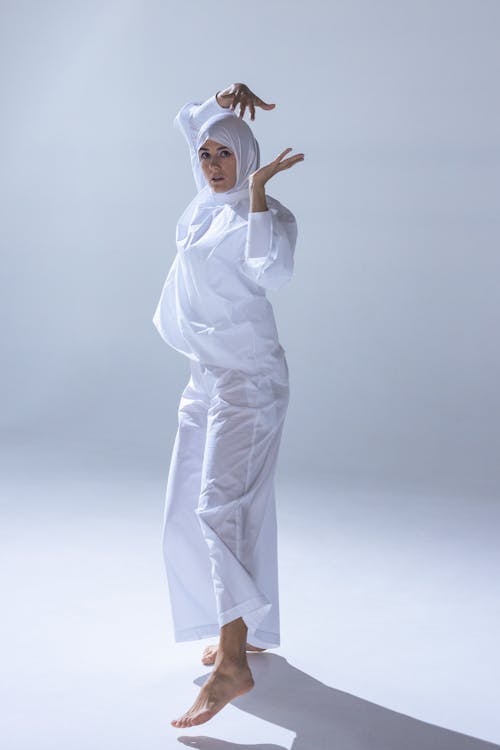 Woman in White Hijab and White Abaya Dancing