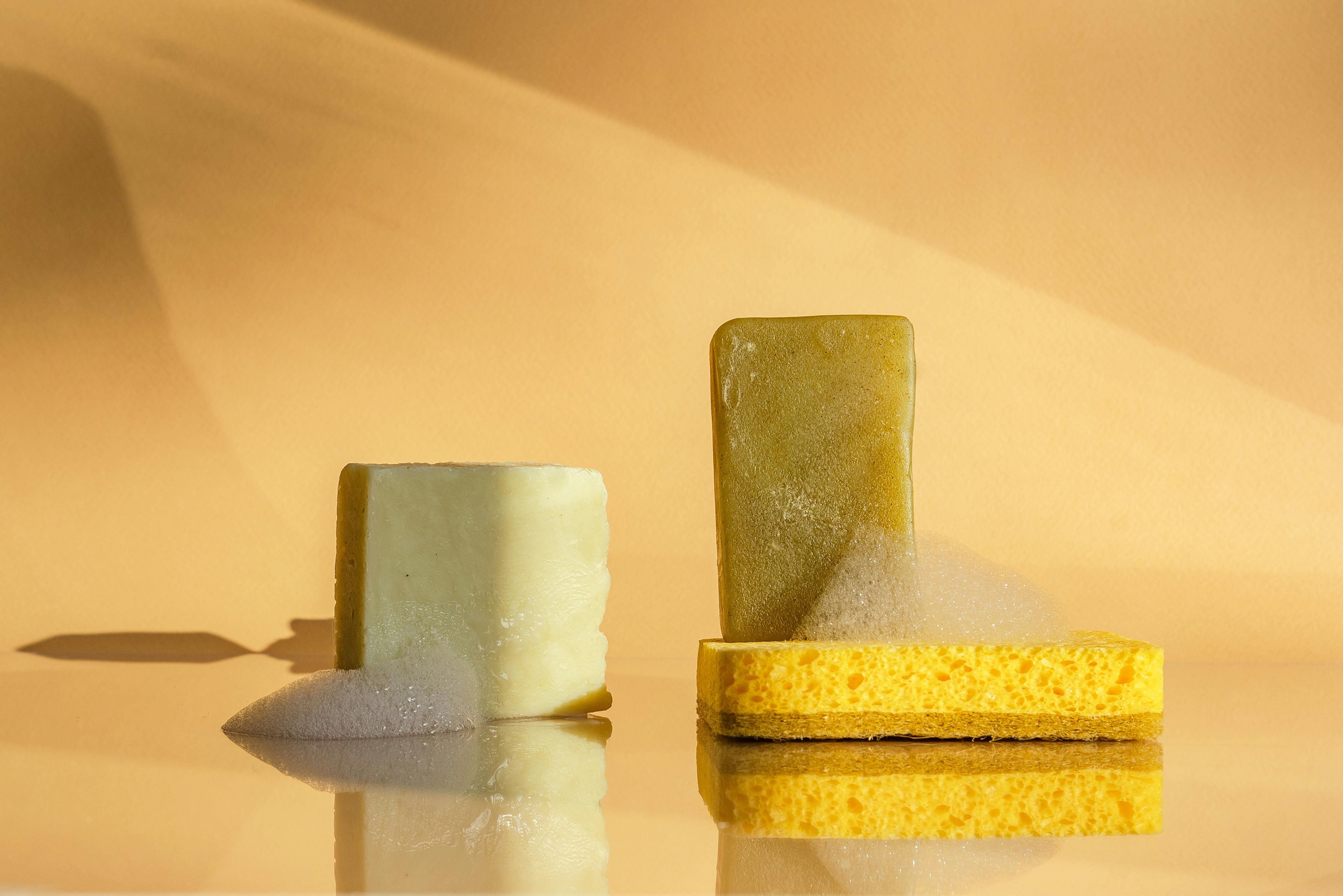 Artistic display of soap bars with yellow sponge and foam in a studio setting.