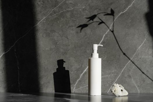 Sophisticated white pump bottle on gray marble with natural shadow play, ideal for skincare branding.