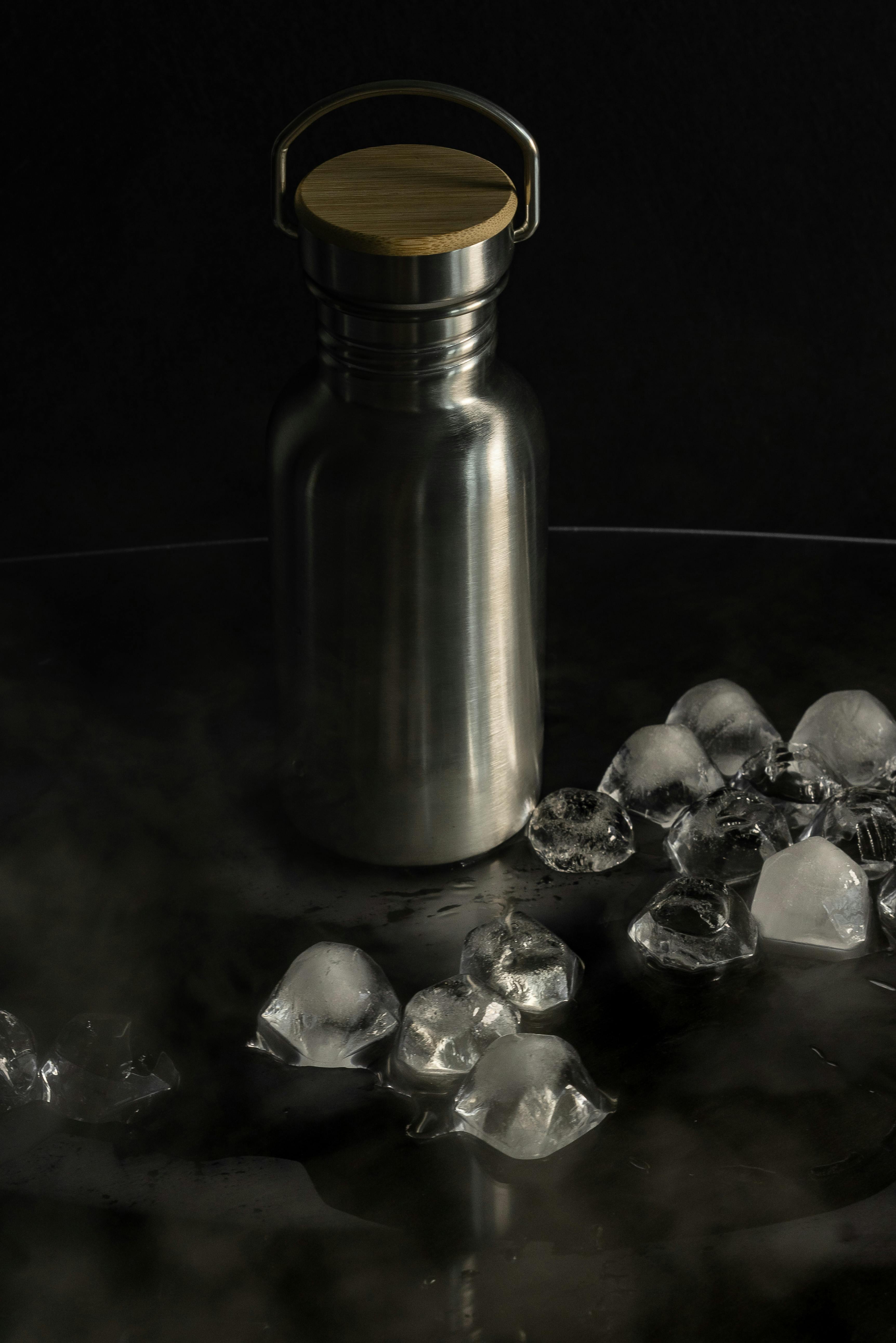 Stainless Steel Flask on a Surface with Ice Cubes · Free Stock Photo