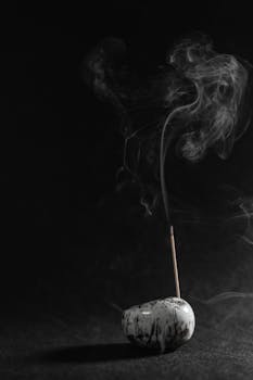 A serene minimalist incense stick in a marble holder releasing gentle smoke on a dark background.