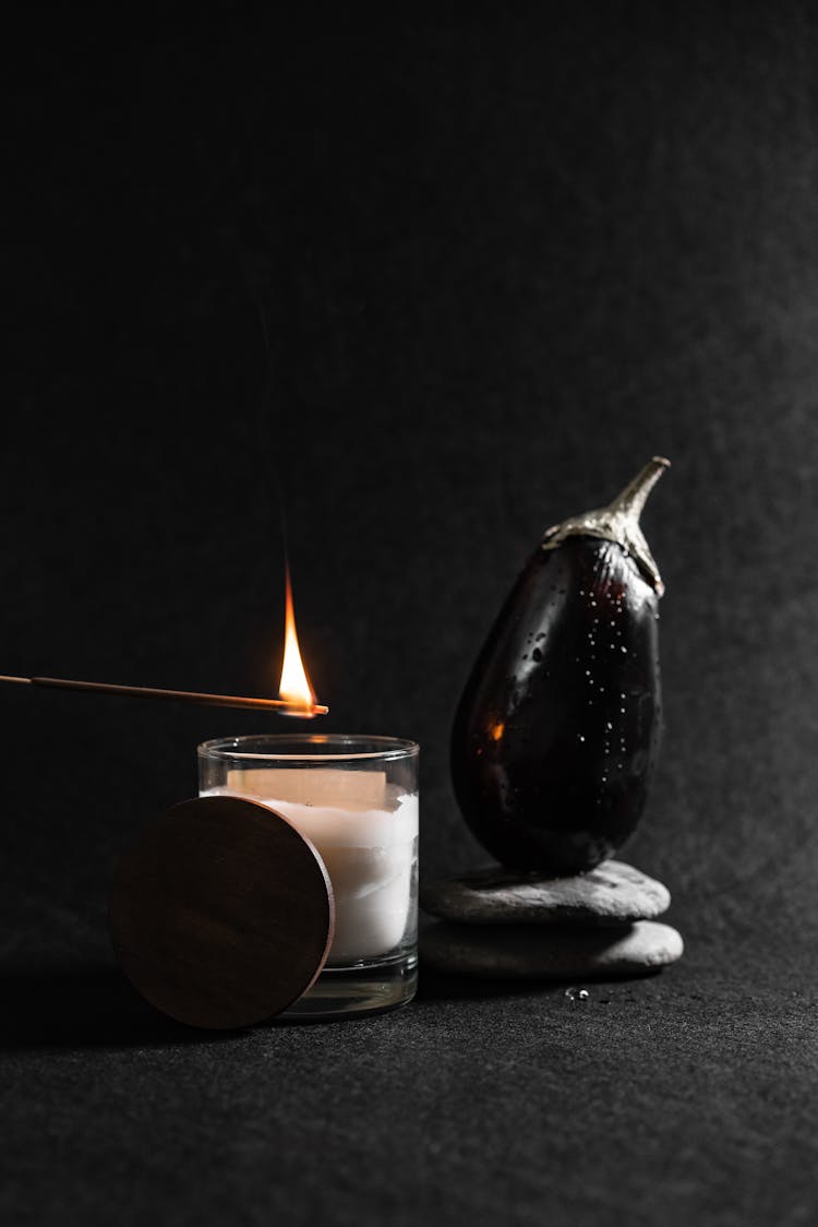 Scented Candle Beside An Eggplant