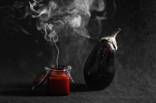 Smoke Coming Out From A Burnt Scented Candle Beside An Eggplant