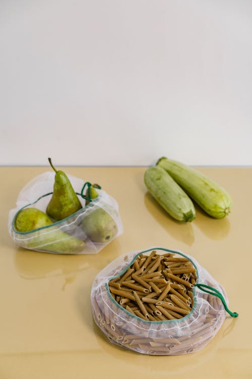 Bags of Pears and Penne Pasta on a Table