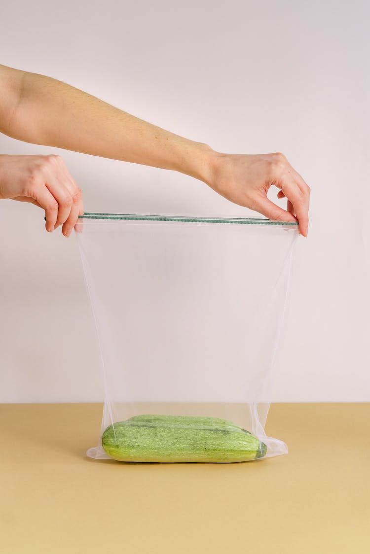 Person Opening A Net Bag With Squashes