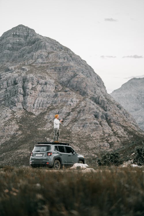 Man Standing on Top of a Car