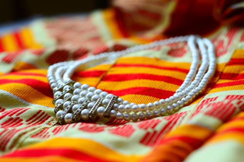 Selective Focus Photo of a Necklace with White Pearls