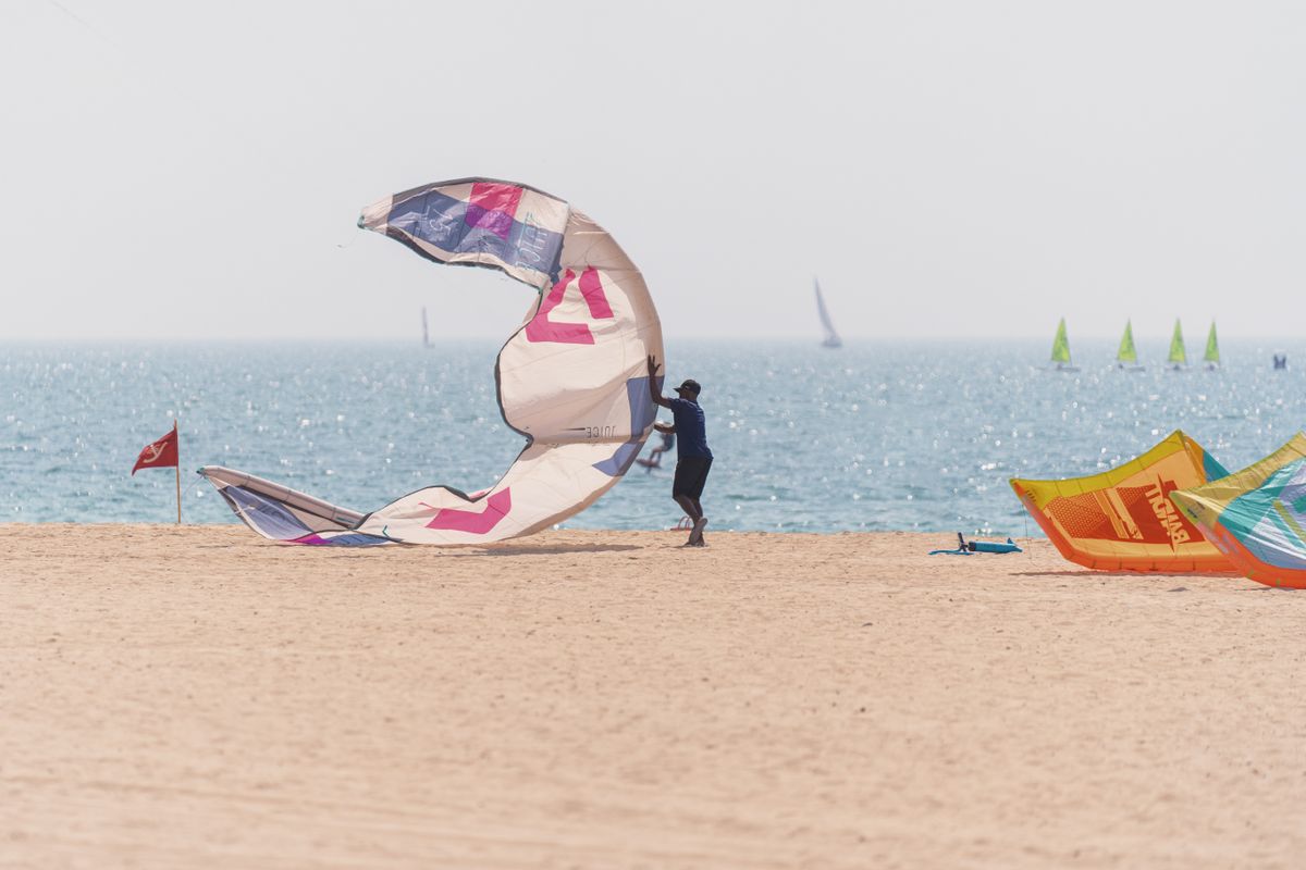 Someone setting up a kite on a Dubai beach in the afternoon