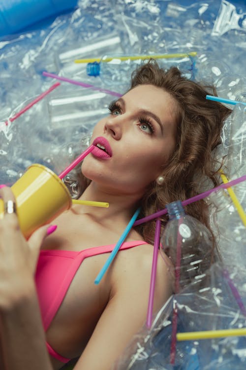 Free Woman in Pink Bikini Top Drinking from Yellow Plastic Cup Stock Photo