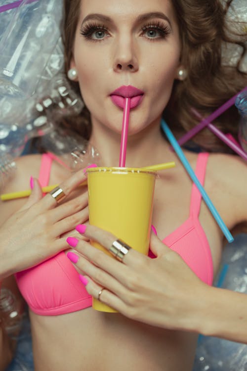 Woman in Pink Bikini Top Sipping on Plastic Cup