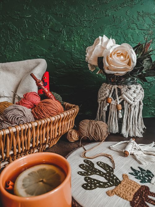 Free Rustic crafting scene with yarn rolls, macrame, and tea cup, perfect for DIY enthusiasts. Stock Photo
