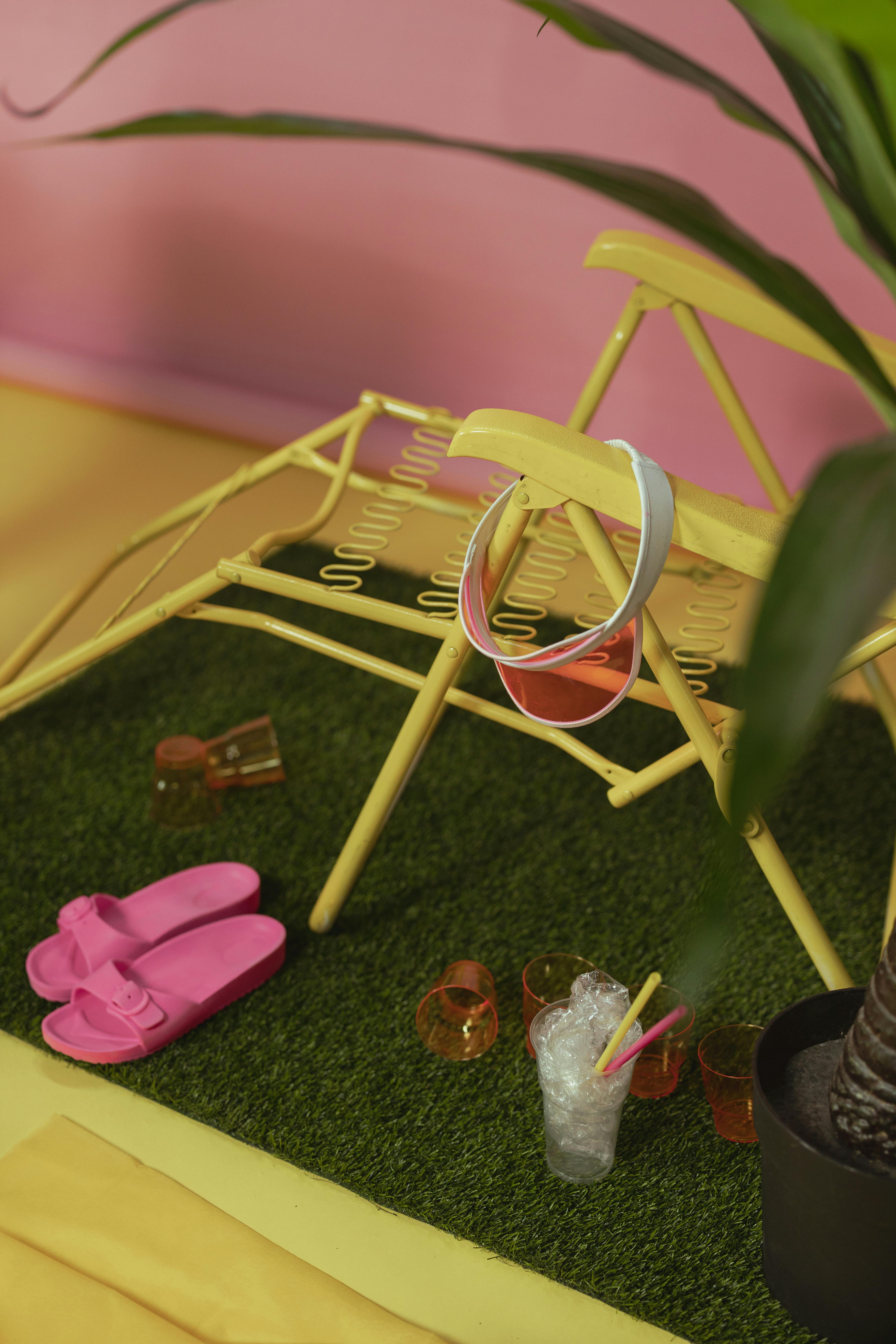 An image of a yellow folding chair on fake grass  