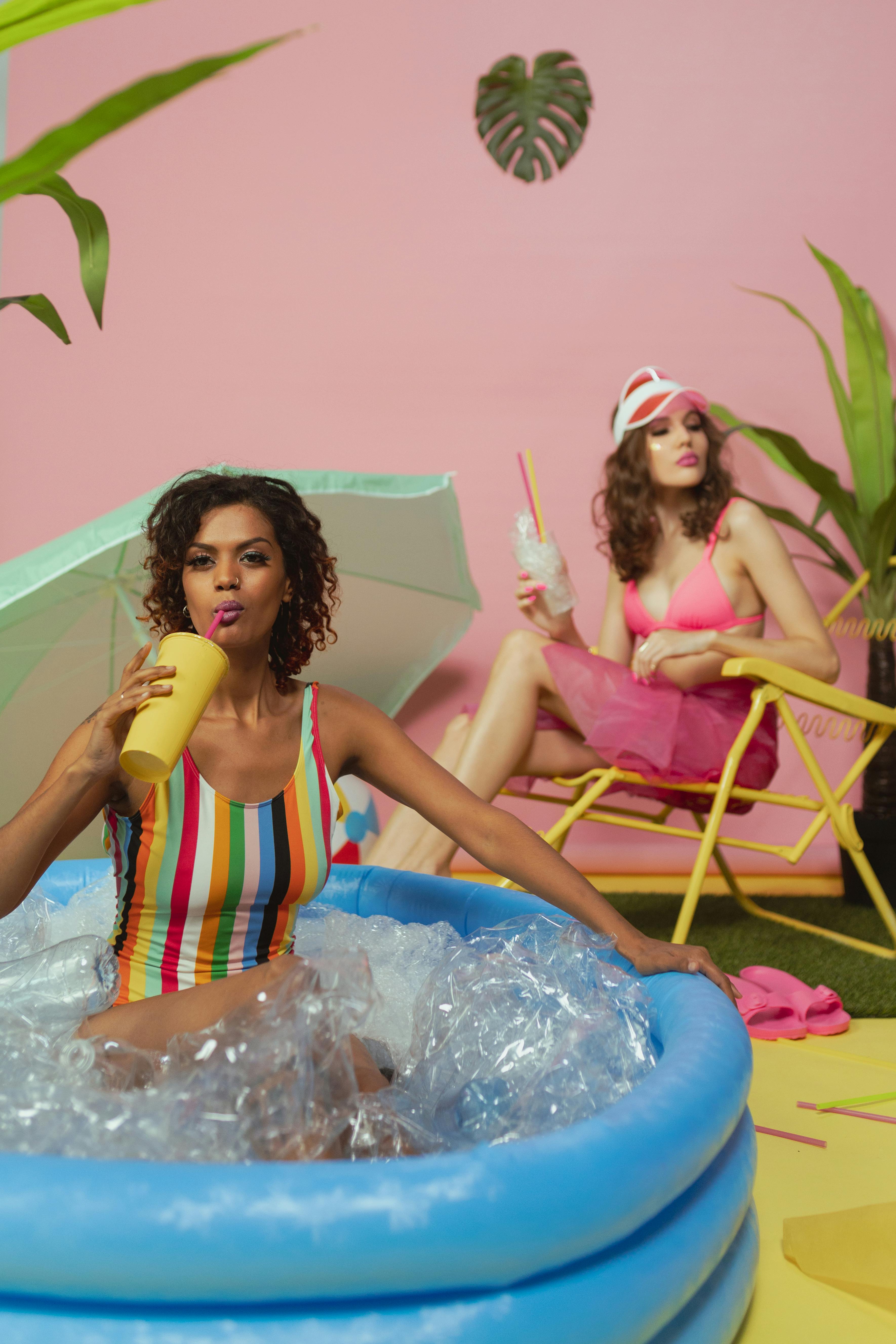 KREA - a photo of a emma watson, holding a drink, laying in a big cute  pastel pink giraffe float, having fun in a pool party in a modern indoors  pool with