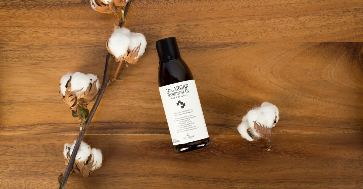 High-quality argan oil bottle on wooden surface with cotton branch. Perfect for natural product ads. - Evidence evidence guide for argan oil skin hydration randomized trial