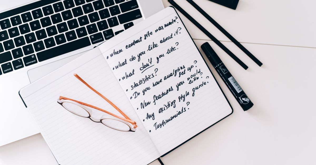 Organized workspace with laptop, notebook, and glasses, perfect for planning and strategy.